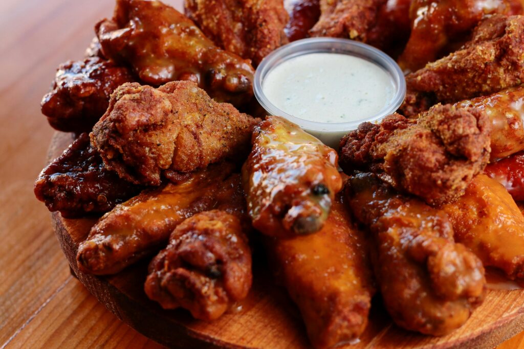 Close-up of assorted buffalo chicken wings served with a creamy dipping sauce.