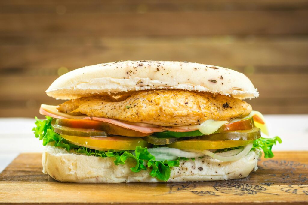 Delicious grilled chicken sandwich with fresh vegetables and lettuce, perfect for a tasty meal.